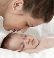 Relief from colic mom kissing baby sleeping